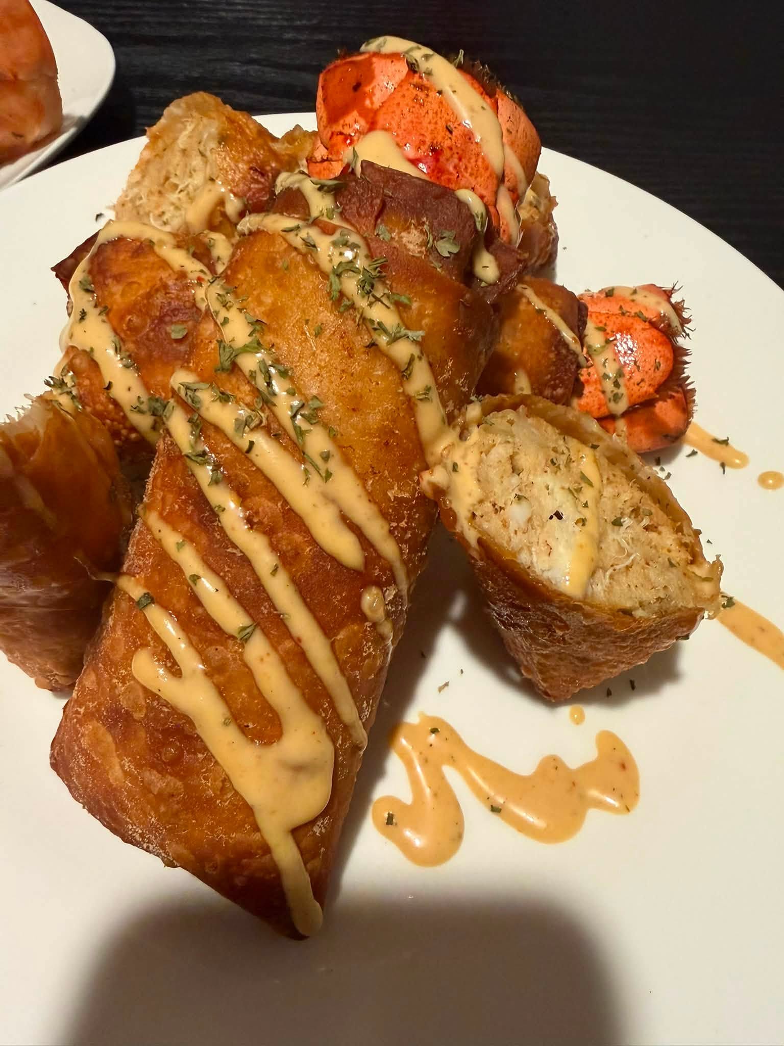 Lobster and crab-stuffed Gold Rolls presented on a white plate